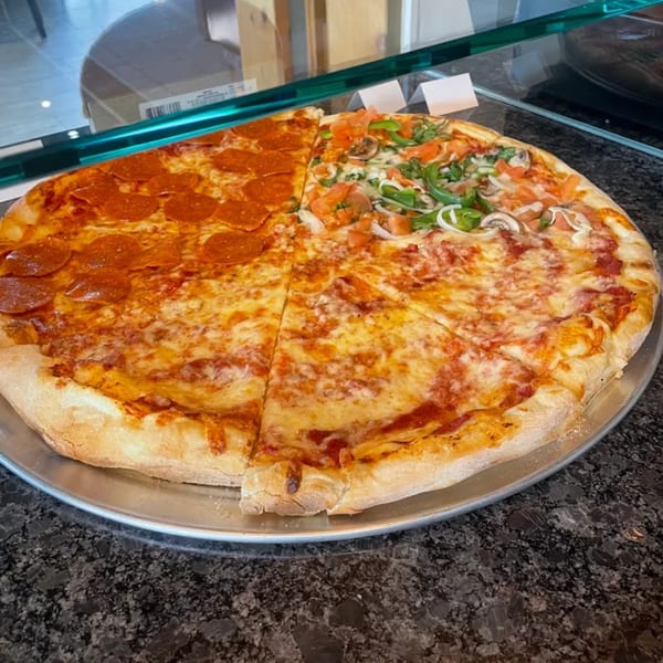 A large ONEWAY Cafe and Pizza pizza, half pepperoni and half supreme, on a metal tray.